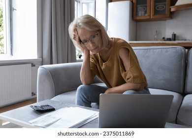 Concerned mature worried homeowner woman checking bills for payment, finding lack of money, overspending, blocked bank accounts, bankruptcy, too high prize, financial mistake, problems, loss - Shutterstock ID 2375011869