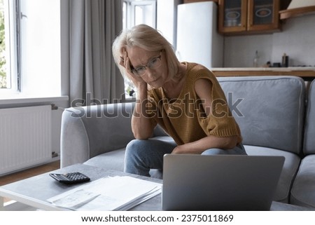 Concerned mature worried homeowner woman checking bills for payment, finding lack of money, overspending, blocked bank accounts, bankruptcy, too high prize, financial mistake, problems, loss