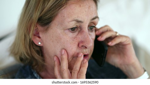 Concerned Older Woman Talking On Phone. Preoccupied Senior Lady Rubbing Face With Hand