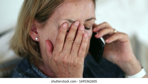 Concerned Older Woman Talking On Phone. Preoccupied Senior Lady Rubbing Face With Hand