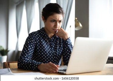 Concerned Puzzled Young Indian Woman Student Professional Use Look At Laptop At Home Office Feel Stressed Frustrated About Computer Software Problem Worried Of Technology Negative Online News Concept