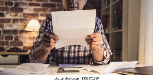 Concerned Sad Man Checking His Domestic Bills, He Has Too Many Expenses