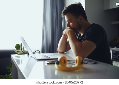 Concerned Serious Man Lost In Thoughts In Front Of Laptop, Focused Male Thinking Of Problem Solution, Worried Puzzled Man Looking At Laptop Screen