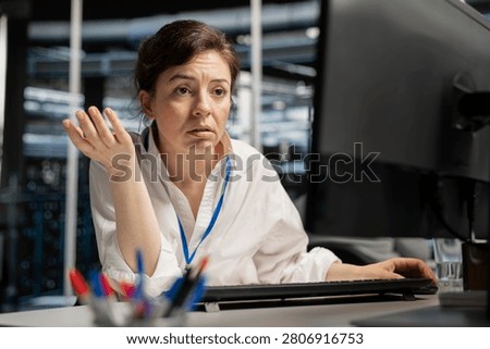 Concerned server hall worker sees error popup on screen while working with software.