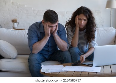 Concerned upset millennial couple counting overspent budget, doing paperwork, thinking on financial problems, high mortgage, rental fees, bad loan conditions, bankruptcy, eviction notice - Shutterstock ID 2184585737