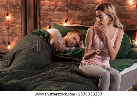 Concerned wife. Young wife feeling concerned while seeing messages from another woman to her husband