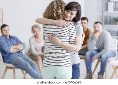 Concerned woman comforting another woman in support group