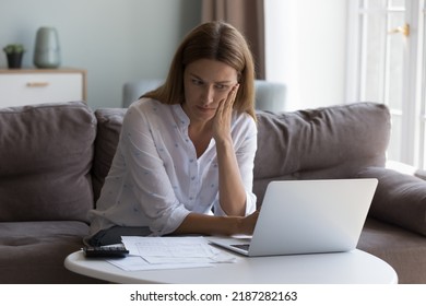 Concerned woman thinks over high domestic utility, huge electricity tariffs looks at laptop reviewing bank statement feels stressed due lack of money to pay bills. Expenses, financial problem