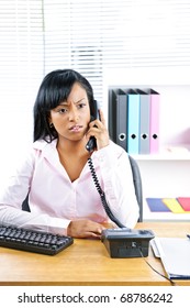 Concerned Young Black Business Woman On Phone At Desk In Office