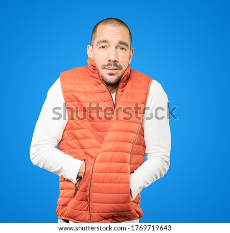 Concerned young man making a gesture of being cold
