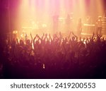 Concert, audience and rock music with hands up from people at dj, band and festival event at a stage with lights. Show, dance and party with excited crowd in rave, techno and entertainment at venue