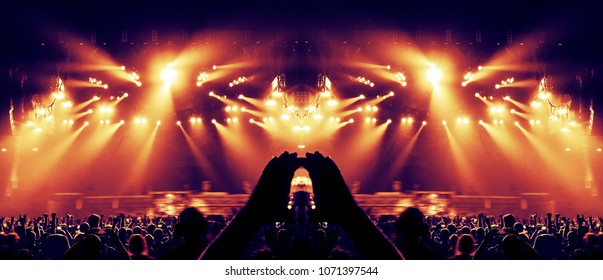 Concert Crowd In A Huge Arena With A Brightly Lit Stage