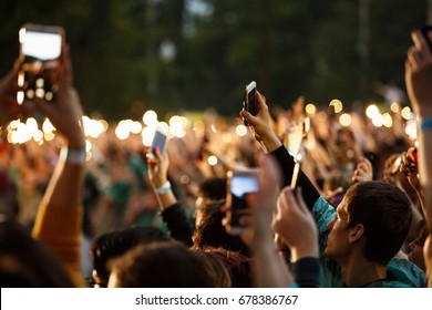 Concert Crowd On Summer Musical Festival.Music Gig Fans Put Hands With Phone Light Up To Favorite Song On Stage.Group Of Young People Partying On Edm Entertainment Event Outside.MOSCOW-4 JULY,201