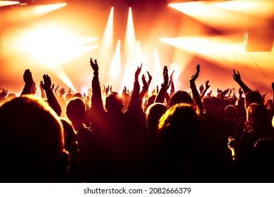 concert crowd at rock concert in front of bright stage lights - Powered by Shutterstock