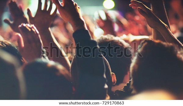 Concert People with Hands Up Excited Attendees\
Listening to Live Music