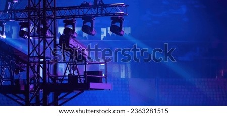 Concert spotlights. Metal structure with lighting equipment. Spotlights above spectator seats. Equipment for concerts. Professional camera on concert mezzanine. Spotlights for concert events