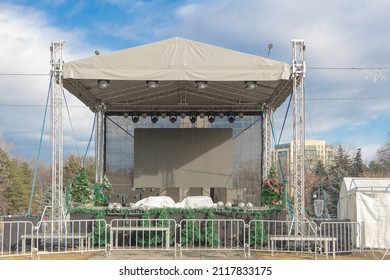 A Concert Stage Outside Under A Blue Cloudy Sky.