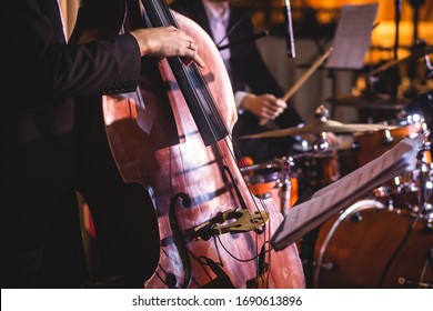 Concert View Of A Contrabass Violoncello Player With Vocalist And Musical During Jazz Orchestra Band Performing Music, Violoncellist Cello Player On Stage
