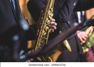 Concert view of a saxophonist, saxophone player with vocalist and musical during jazz orchestra performing music on stage

