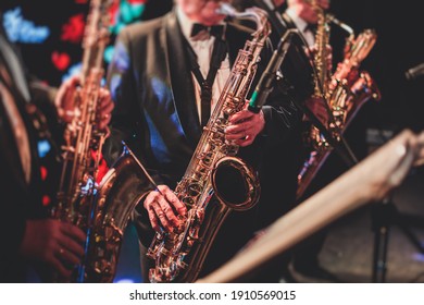 Konzertsicht eines Saxophonisten, Saxophonsaxonspielers mit Gesang und Musical während des Jazzorchesters, das auf der Bühne Musik aufführt 