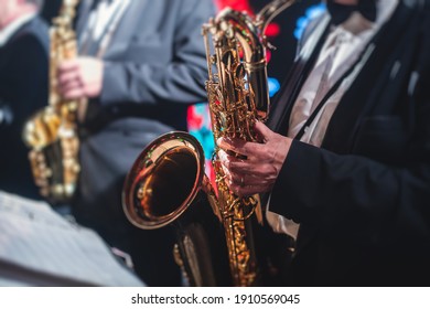 Concert view of a saxophonist, saxophone sax player with vocalist and musical during jazz orchestra performing music on stage  - Shutterstock ID 1910569045
