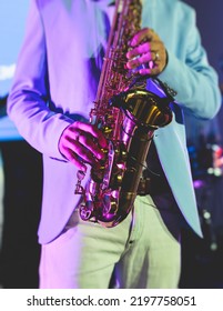 Concert view of saxophonist, a saxophone sax player with vocalist and musical band during jazz orchestra show performing music on stage in the scene lights
 - Shutterstock ID 2197758051