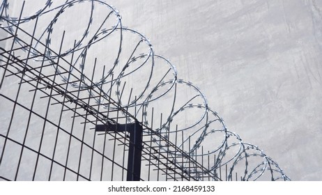 Concertina barb wire, heavy duty, metal fence. A prison, crime concept low angle shot