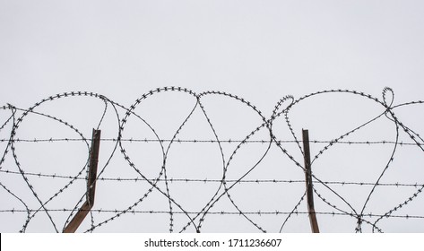 Concertina Wire. Grey Cloudy Sky