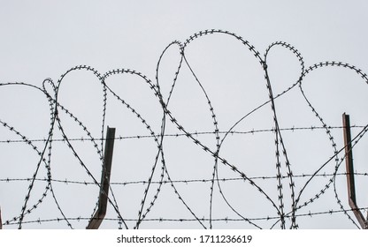 Concertina Wire. Grey Cloudy Sky