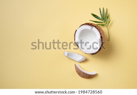 Concet of eco frendly flat lay. Fresh coconut and slices  on yellow  background. Healthy and vegan food. Top view and copy space image