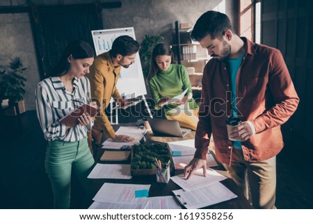 Concetrated managers work important progress analysis plan papers lie table desk bearded man read report smart girl write copybook notes project two partners discus career aims in office workplace
