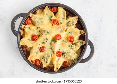 
Conchiglioni Pasta Shells Stuffed With Spinach, Baked With Tomatoes And Vegan Cheese Sauce In A Pan. View From Above. Copy Space