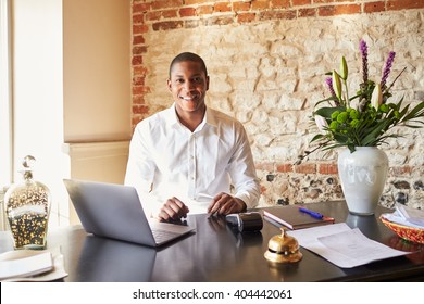 Concierge Working At The Check In Desk Of A Boutique Hotel