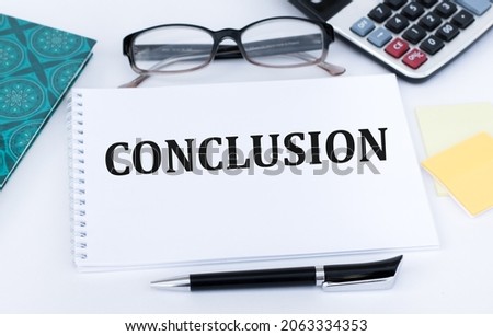 Conclusion text on a notepad on an office table near a pen, calculator, glasses, notepad