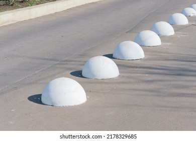 Concrete ball spheres lie down on the road. Bollards. Urban. Pavement. Control. Drive. Grey. Path. Planet. Public. Security. Traffic. Nobody. Object. Row. Stop. Problem. Solution