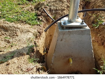 The concrete bar that forms the base for the light pole has a large bolt to hold the light pole. Placed in underground holes