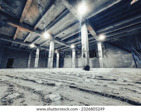 Concrete basement with pillars, lanterns.