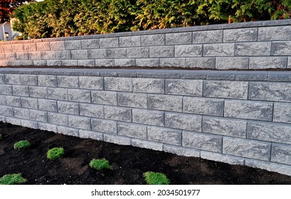 concrete block retaining wall, built as a 2 tier wall into an existing garden landscape, gray color block - Shutterstock ID 2034501977