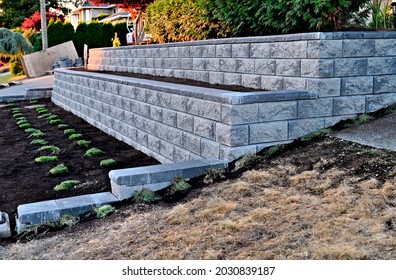 concrete block wall, retaining wall built as 2 tier wall into existing garden landscape, staggered wall, new construction - Shutterstock ID 2030839187