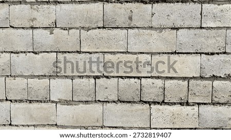Concrete blocks create rustic surface. Worn industrial brick surface displaying textured gray masonry. Weathered concrete masonry showing signs of aging with mortar joints and textured surfaces