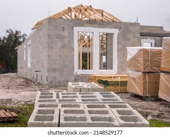 Concrete Blocks, Lumber, And Shrink-wrapped Insulation Boards By Single-family House Under Construction On A Cloudy Morning In Southwest Florida. Light Digital Oil-painting Effect.