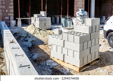 Concrete blocks stacked on pallets outdoors in front of a detached house under construction in the suburbs of Paris, France.