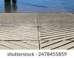 Concrete boat ramp with grooved lines leading to the ocean