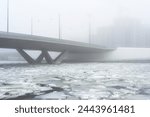 concrete bridge in heavy fog in early spring during ice drift 