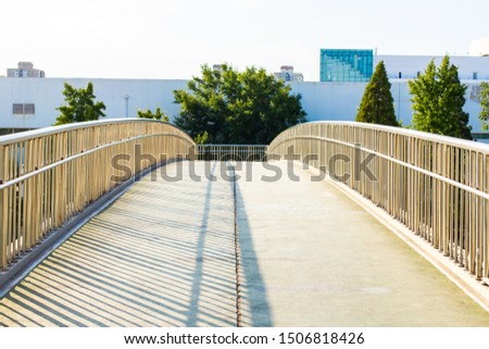 Concrete bridge with metal railing. Curved foot bridge. Street photo.