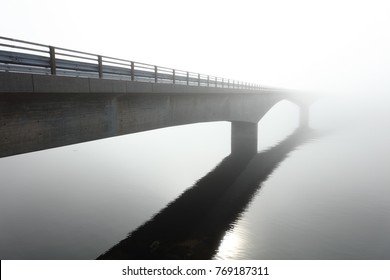 Concrete bridge over the sea in the middle of a deep fog