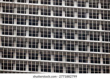 Concrete building framework under construction showing grid pattern of unfinished facade
