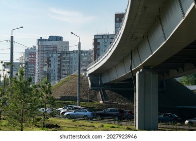 Concrete car overpass in the city center. Busy car traffic under the overpass. Concrete overpass with massive concrete supports.