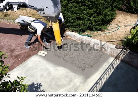 Concrete cement work with small gravel lowering garage pump worker
