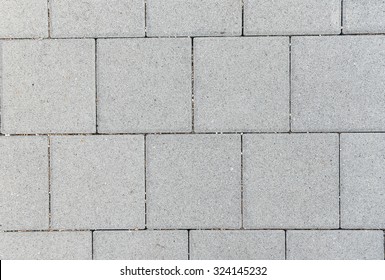 Concrete or cobble gray square pavement slabs or stones  for floor, wall or path. Traditional fence, court, backyard or road paving.
